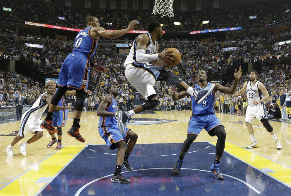 Memphis Grizzlies guard Mike Conley, center, drives under the basket in front of Oklahoma City Thunder defenders Russell Westbrook (0), Reggie Jackson (15) and Serge Ibaka (9) during the second half of Game 4 of an opening-round NBA basketball playoff series Saturday, April 26, 2014, in Memphis, Tenn. Oklahoma City won in overtime 92-89. (AP Photo/Mark Humphrey)