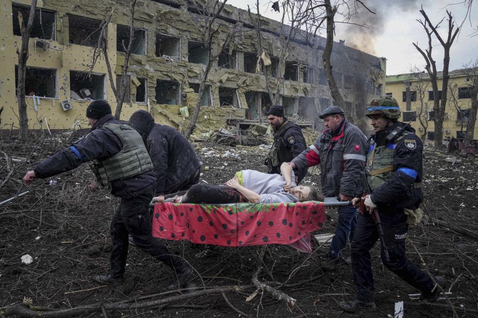 FILE - Ukrainian emergency employees and volunteers carry an injured pregnant woman from a maternity hospital damaged by shelling in Mariupol, Ukraine, March 9, 2022. The woman and her baby later died. (AP Photo/Evgeniy Maloletka, File)