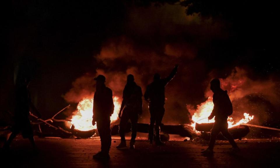 Demonstrators are seen at a barricade as fires burn in Cali on 11 May.