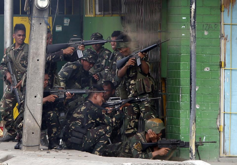 Government soldiers fire their weapons towards positions held by Muslim rebels from the Moro National Liberation Front (MNLF) during a firefight in Zamboanga city, in southern Philippines, September 12, 2013. Fighting between security forces and the rogue Muslim rebels seeking to declare an independent state escalated in Zamboanga city on Thursday and spread to a second island, officials said. U.S.-trained commandos exchanged gunfire with a breakaway faction of the MNLF holding dozens of hostages in Zamboanga City, on the southernmost island of Mindanao, army spokesman Domingo Tutaan said. REUTERS/Erik De Castro (PHILIPPINES - Tags: CIVIL UNREST CONFLICT POLITICS)