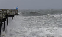 An onlooker checks out the heavy surf at the Avalon Fishing Pier in Kill Devil Hills, N.C., Thursday, Sept. 13, 2018 as Hurricane Florence approaches the east coast. (AP Photo/Gerry Broome, File)