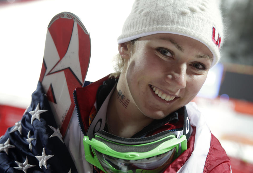 Women's slalom gold medal winner Mikaela Shiffrin of the United States wears an American flag after a flower ceremony at the Sochi 2014 Winter Olympics, Friday, Feb. 21, 2014, in Krasnaya Polyana, Russia.(AP Photo/Gero Breloer)