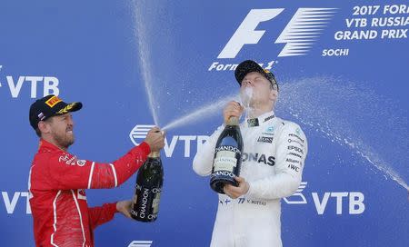 Formula One - F1 - Russian Grand Prix - Sochi, Russia - 30/04/17 - Winner and Mercedes Formula One driver Valtteri Bottas (R) of Finland and second-placed Ferrari Formula One driver Sebastian Vettel of Germany spray champagne on the podium. REUTERS/Maxim Shemetov