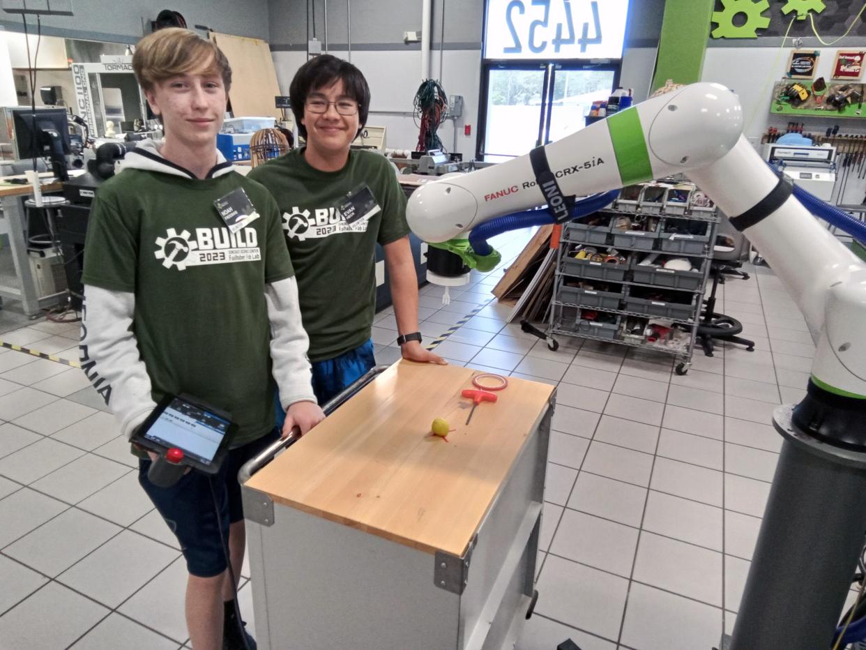 Fab Lab volunteers Noah and Evan test the FANUC robotic arm provided by RND Automation – Florida's largest custom robotics, packaging and assembly machinery manufacturer.