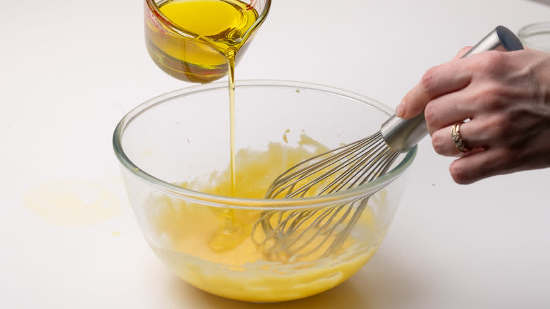 pouring olive oil into aioli