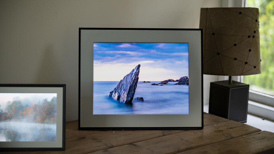 Aura Walden digital photo frame on a wooden sideboard alongside the smaller Aura Carver Mat