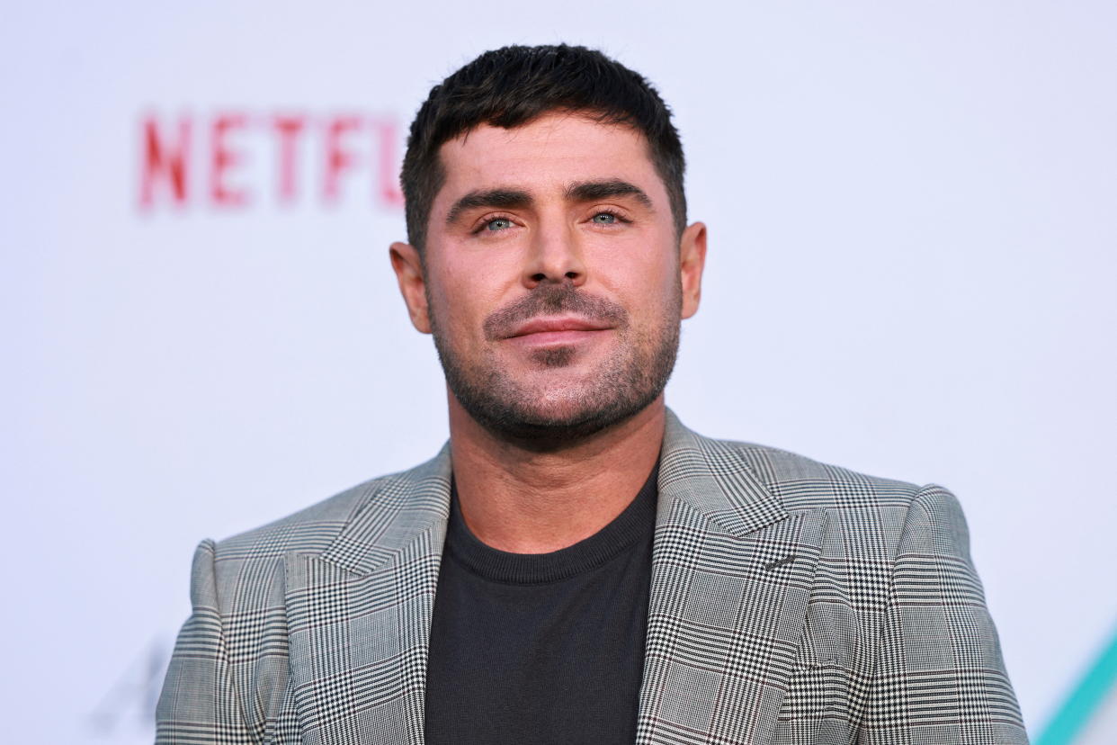 Zac Efron poses for photographers at a film premiere.