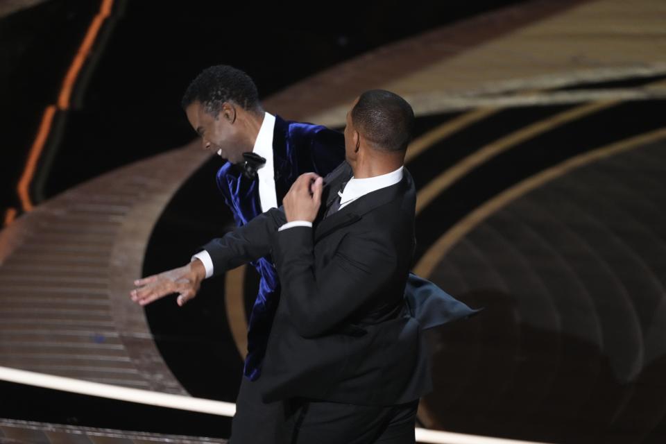 Will Smith slaps Chris Rock as he presents the award for best documentary feature during the 94th Academy Awards. Smith slapped the comedian after he made a joke about the actor's wife, Jada Pinkett Smith.