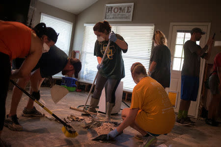 Samaritans help clear debris from the house of a neighbor which was left flooded from Tropical Storm Harvey in Houston, Texas, U.S. September 3, 2017. REUTERS/Adrees Latif