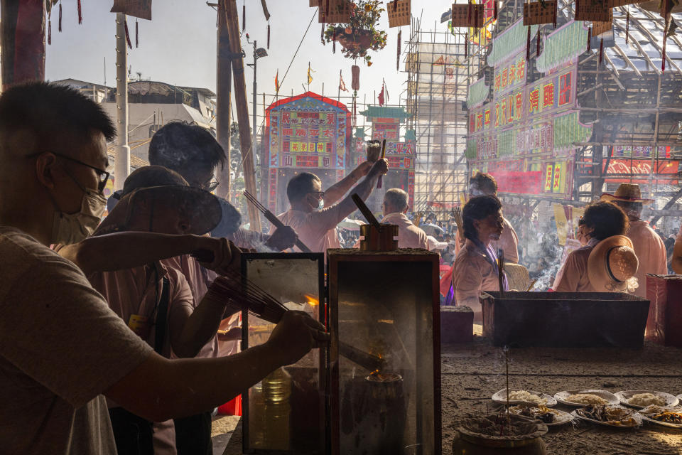 Worshippers burn incense at a temple during the Bun Festival in Cheung Chau Island in Hong Kong, Friday, May 26, 2023. (AP Photo/Louise Delmotte)