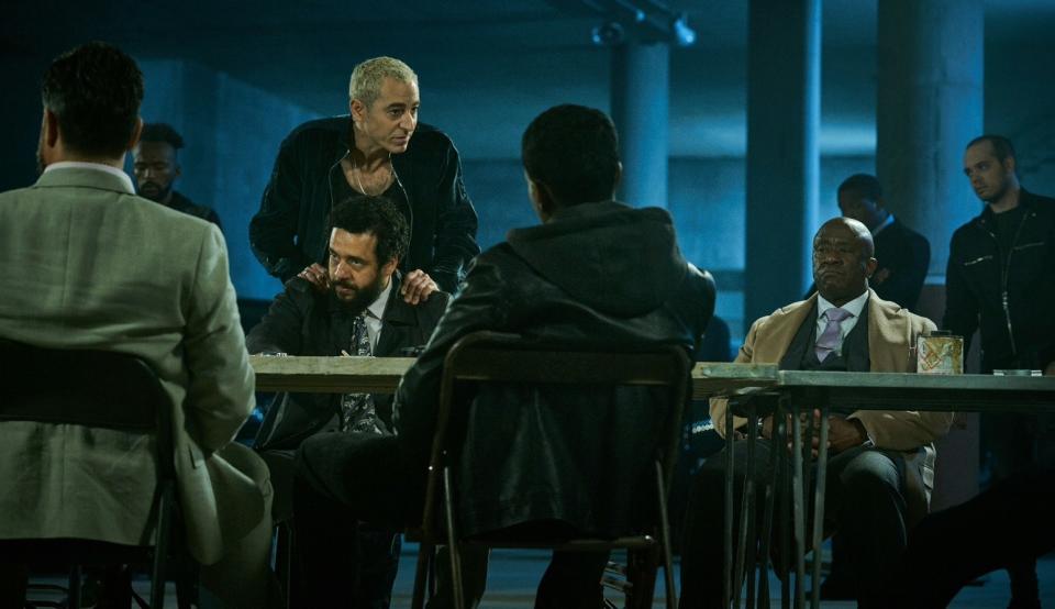 A table of gangsters from different crime families assemble for an illicit meeting
