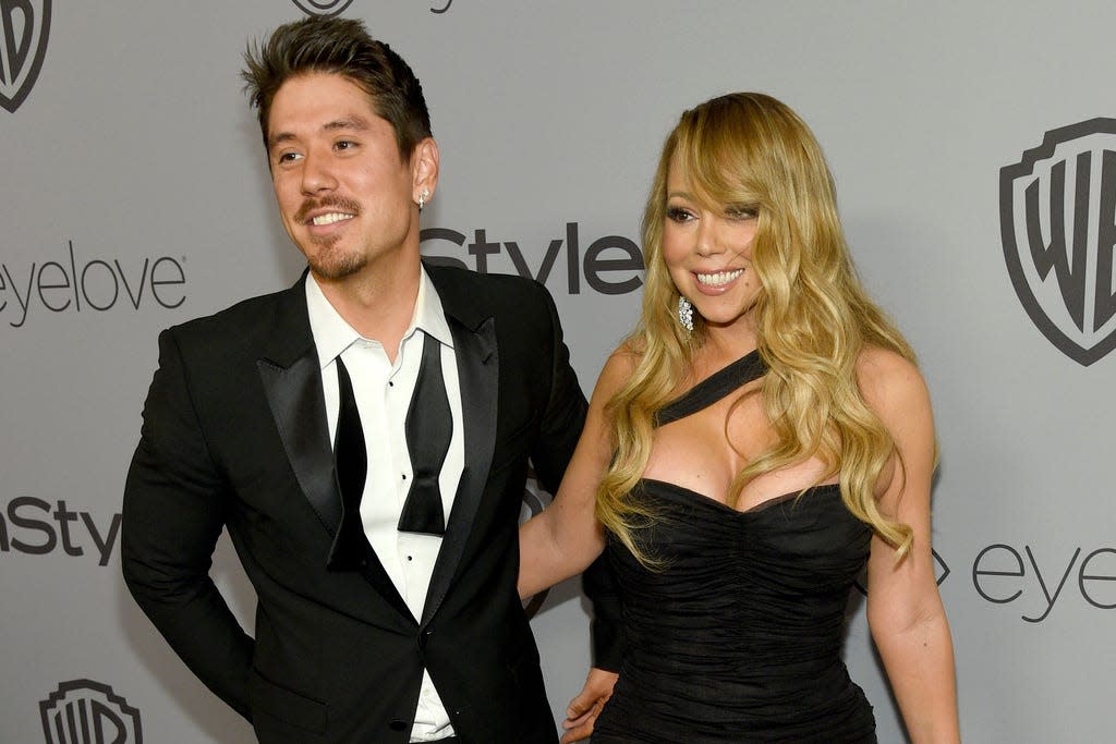 Two people in front of a white background smile for the camera