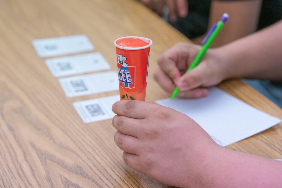 A Fort Collins High School student cools off with an ice pop while completing work in a journalism class Tuesday, Sept. 26, 2023. Because the school does not have a working air conditioning system, the second-floor classroom uses four portable fans to circulate air on hot days.