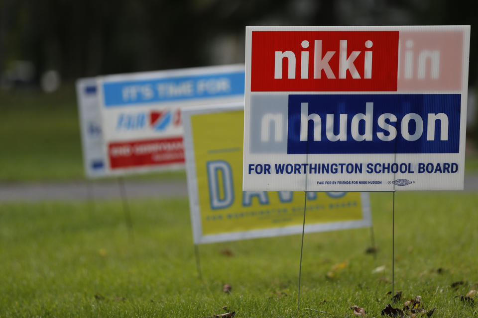 Campaign yard signs line a yard Thursday, Oct. 7, 2021, in Worthington, Ohio. Across Ohio and the nation, parental protests over social issues like mask mandates, gender-neutral bathrooms, teachings on racial history, sexuality and mental and emotional health are being leveraged into school board takeover campaigns. (AP Photo/Jay LaPrete)