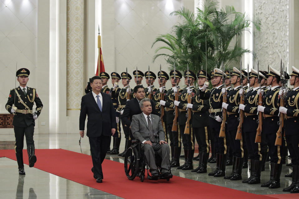 FILE - In this Dec. 12, 2018 file photo, Ecuador's President Lenin Moreno, right, and Chinese President Xi Jinping review an honor guard during a welcome ceremony at the Great Hall of the People in Beijing, China. In 2020, Ecuador negotiated to delay for a year nearly $900 million in debt payments serviced by oil shipments, and in 2021 the U.S. International Development Finance Corporation signed an agreement with Ecuador to finance up to $2.8 billion in infrastructure projects, money that it said could be used to “refinance predatory Chinese debt.” (AP Photo/Andy Wong, File)