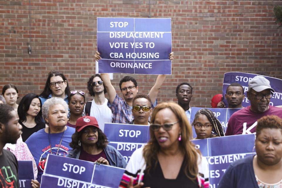 In this Tuesday, July 23, 2019 photo, activist Jose Reuena, center in back row, holds a placard during a news conference and rally in Chicago. (AP Photo/Amr Alfiky)