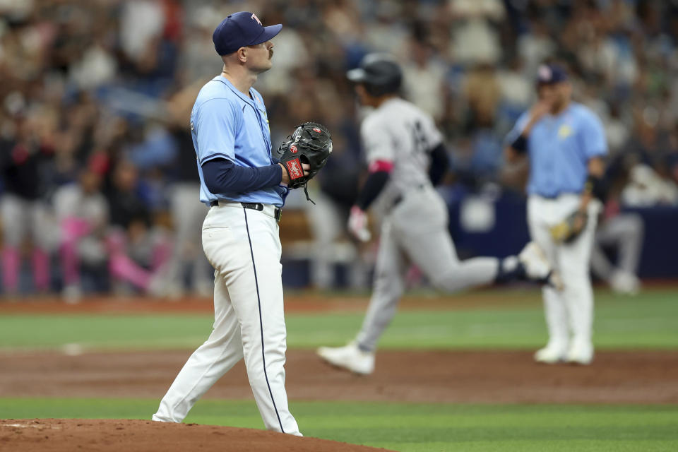 Tampa Bay Rays starting pitcher Tyler Alexander, left, reacts as New York Yankees' Jahmai Jones, back center, rounds the bases on a solo home run during the third inning of a baseball game Sunday, May 12, 2024, in St. Petersburg, Fla. (AP Photo/Mike Carlson)