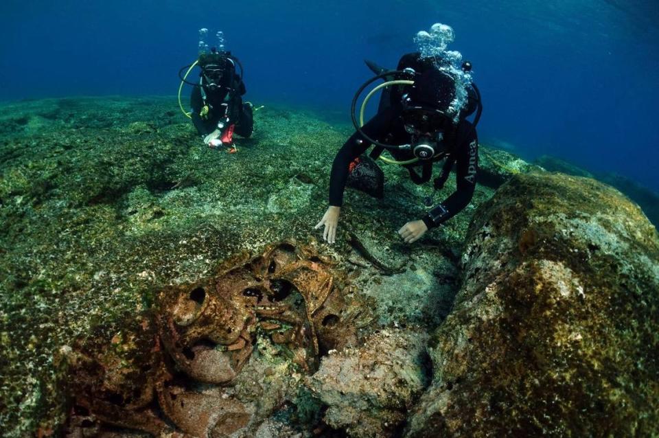 Divers examine underwater artifacts