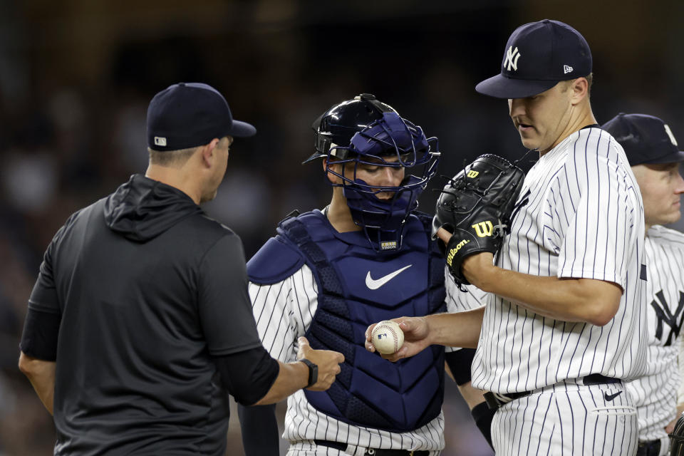 New York Yankees pitcher Jameson Taillon hands the ball to manager Aaron Boone as he is taken out of the baseball game against the Toronto Blue Jays during the sixth inning Friday, Aug. 19, 2022, in New York. (AP Photo/Adam Hunger)