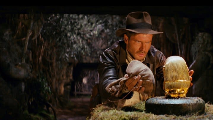 Harrison Ford as Indiana Jones staring at a golden idol in "Raiders of the Lost Ark."