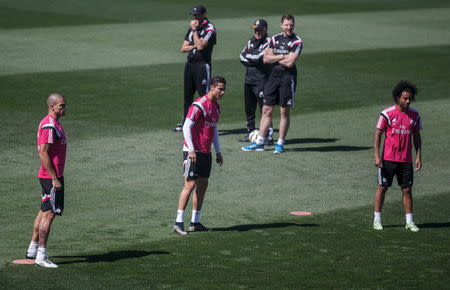 Real Madrid coach Carlo Ancelotti (back C) looks on behind Real Madrid's Cristiano Ronaldo (front C), Pepe (L) and Marcelo during a training session at Valdebebas, outside Madrid, Spain, May 22, 2015. REUTERS/Andrea Comas