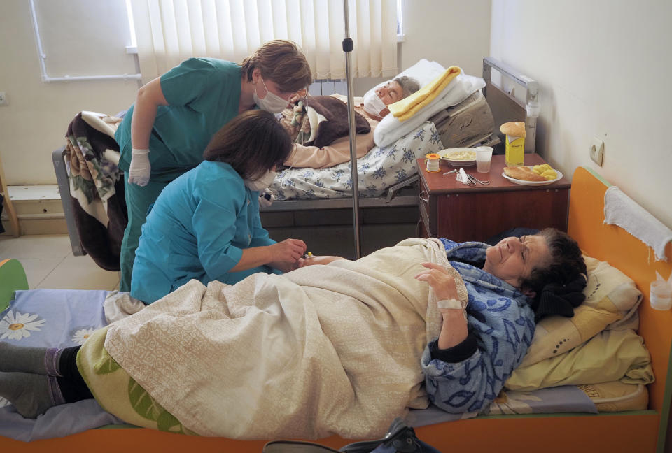 Nurses administer medicine to a patient wounded from shelling by Azerbaijan's artillery in a hospital, during a military conflict in Stepanakert, the separatist region of Nagorno-Karabakh, Saturday, Oct. 17, 2020. The latest outburst of fighting between Azerbaijani and Armenian forces began Sept. 27 and marked the biggest escalation of the decades-old conflict over Nagorno-Karabakh. The region lies in Azerbaijan but has been under control of ethnic Armenian forces backed by Armenia since the end of a separatist war in 1994. (AP Photo)