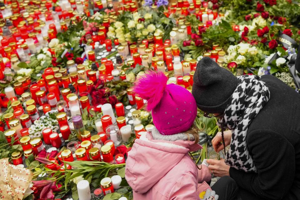 Mourners lay candle lights outside the headquarters of Charles University for the victims of mass shooting in Prague, Czech Republic, Friday, Dec. 22, 2023. A lone gunman opened fire at a university on Thursday, killing more than a dozen people and injuring scores of people. in downtown Prague, Czech Republic, Friday, Dec. 22, 2023. (AP Photo/Petr David Josek)