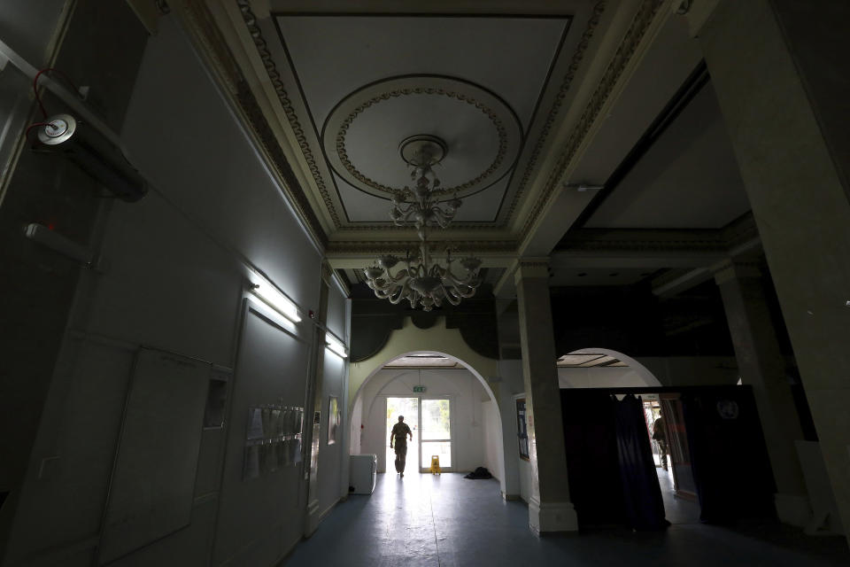 In this Friday, April 19, 2019, photo, a U.N. peacekeeper walks through the lobby at the Ledra Palace hotel inside the U.N. buffer zone in divided capital Nicosia, Cyprus. This grand hotel still manages to hold onto a flicker of its old majesty despite the mortal shell craters and bullet holes scarring its sandstone facade. Amid war in the summer of 1974 that cleaved Cyprus along ethnic lines, United Nations peacekeepers took over the Ledra Palace Hotel and instantly turned it into an emblem of the east Mediterranean island nation's division. (AP Photo/Petros Karadjias)