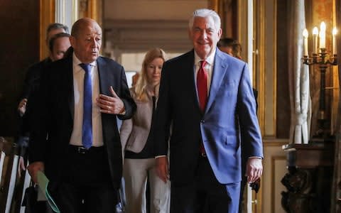 US Secretary of State Rex Tillerson listens to French Foreign Affairs Minister Jean-Yves Le Drian as they walk together before a meeting with diplomats - Credit: CHRISTIAN HARTMANN/AFP/Getty Images