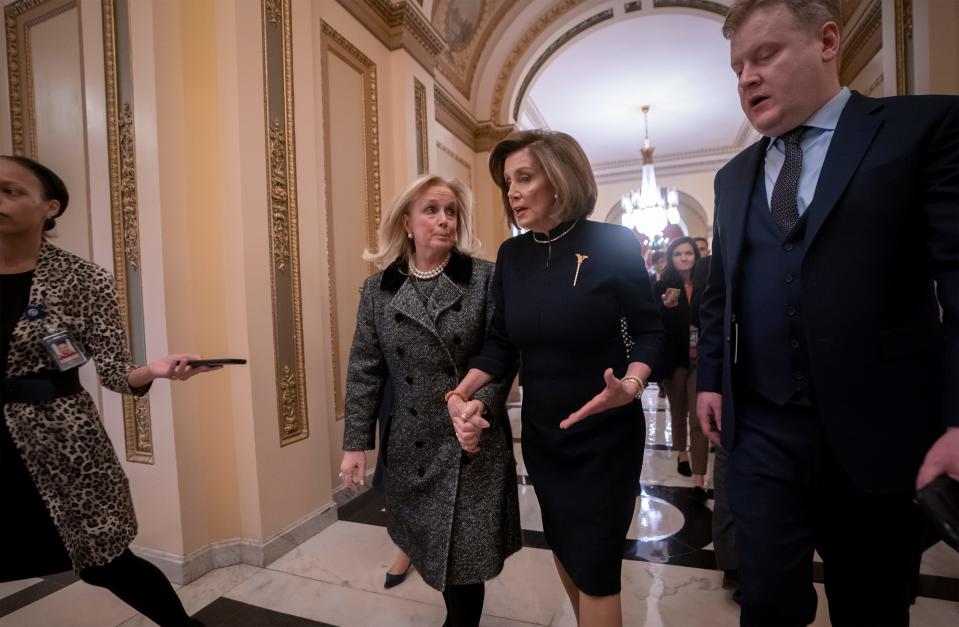 Speaker of the House Nancy Pelosi, D-Calif., holds hands with Rep. Debbie Dingell, D-Mich., as they walk to the chamber where the Democratic-controlled House of Representatives begins a day of debate on the impeachments charges against President Donald Trump for abuse of power and obstruction of Congress, at the Capitol in Washington, Dec. 18, 2019.