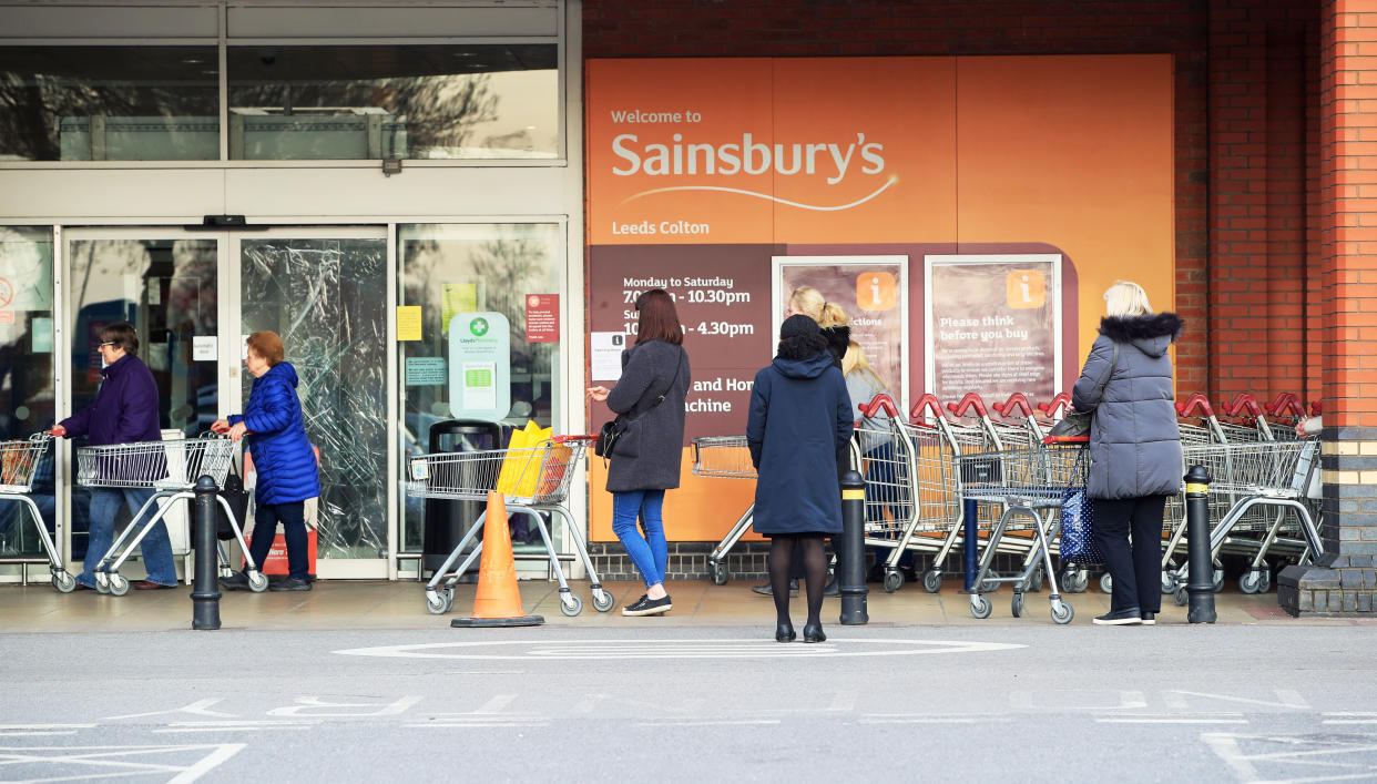 People observe social distancing while queuing at a Sainsbury's supermarket at Colton, on the outskirts of Leeds, the day after Prime Minister Boris Johnson put the UK in lockdown to help curb the spread of the coronavirus.