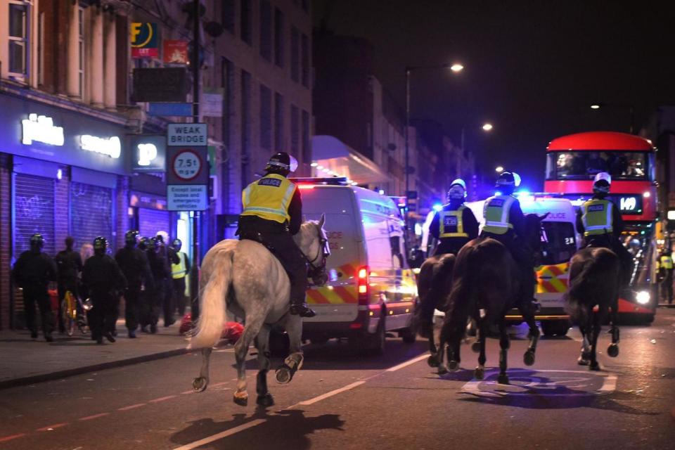 Police horses are drafted in to the riot. (PA)