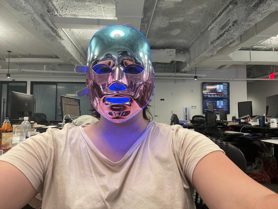 Person in office with LED face mask with blue lighting.