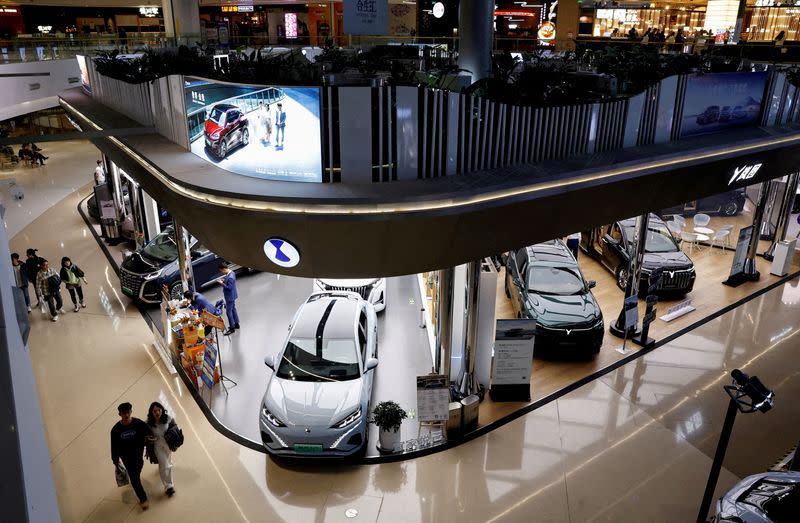 FILE PHOTO: Electric vehicles are displayed at a shopping mall in Beijing