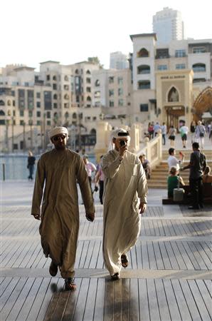 Men walk in Dubai October 9, 2013. REUTERS/Ahmed Jadallah