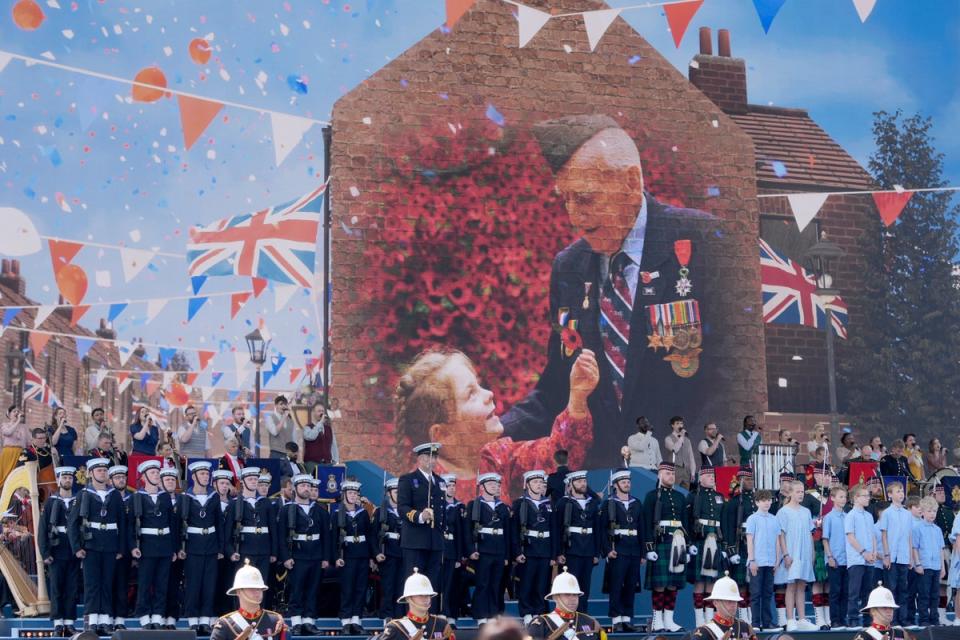 Pictures are shown on a huge screen during the UK's national commemorative event (Kin Cheung/PA Wire)