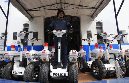 A member of Philippine National Police poses for a picture with a patrol segway motorcycle in front of a police station in Manila September 15, 2014. REUTERS/Romeo Ranoco