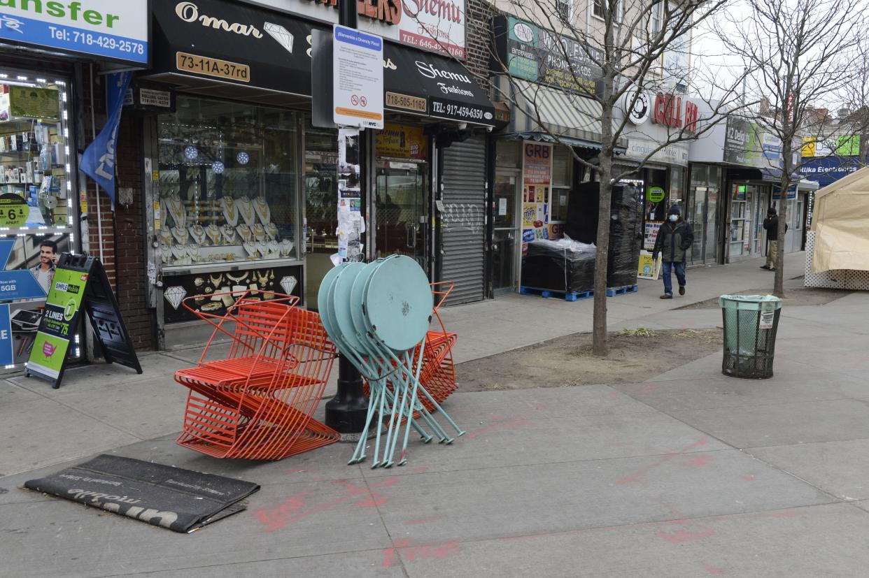 Tables and chairs for outdoor dining are stacked on 37th Rd. in the Jackson Heights neighborhood of Queens, New York City.