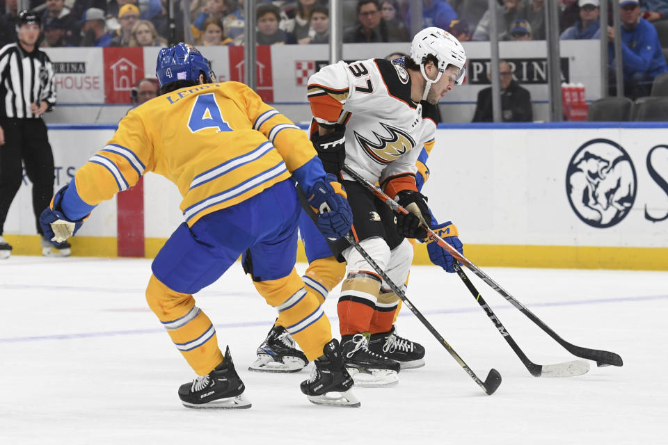Anaheim Ducks' Mason McTavish (37) fights for the pucks against St. Louis Blues' Nick Leddy (4) during the first period of an NHL hockey game, Monday, Nov. 21, 2022, in St. Louis. (AP Photo/Michael Thomas)