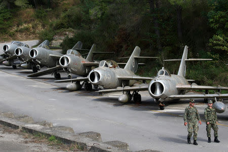 Albanian Air Force members walk near MiG-15 jet fighters in Kucova Air Base in Kucova, Albania, October 3, 2018. REUTERS/Florion Goga