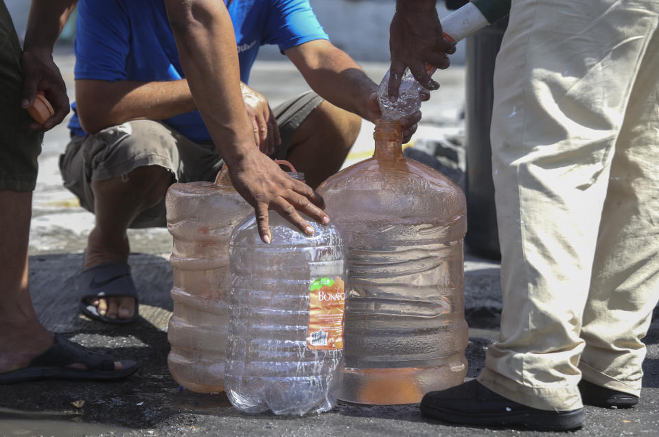 Neighbors collect water a public collection point in Monterrey, Mexico, Monday, June 20, 2022. Local authorities began restricting water supplies in March, as a combination of an intense drought, poor planning and high use has left the three dams that help supply the city dried up, with thousands of homes not receiving any water for weeks. (AP Photo)