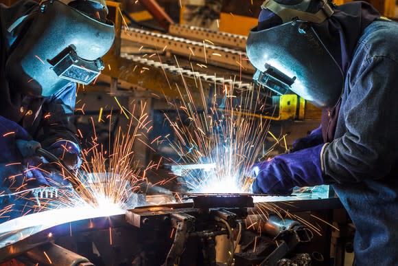 Two people welding.