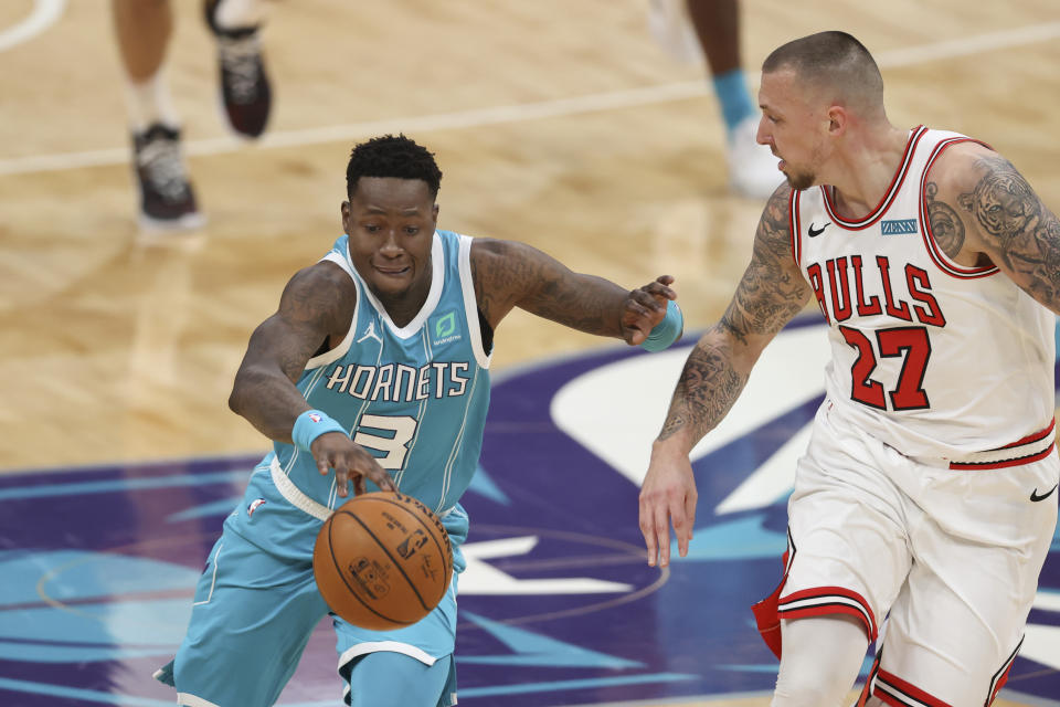 Charlotte Hornets guard Terry Rozier, left, pushes the ball upcourt against Chicago Bulls center Daniel Theis during the first half of an NBA basketball game in Charlotte, N.C., Thursday, May 6, 2021. (AP Photo/Nell Redmond)