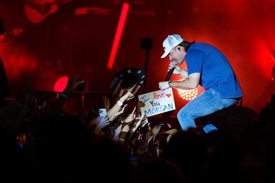 Morgan Wallen fist bumps a fan from the stage as he performs on day 3 of the Country Thunder music festival on April 9, 2022, in Florence, Arizona.