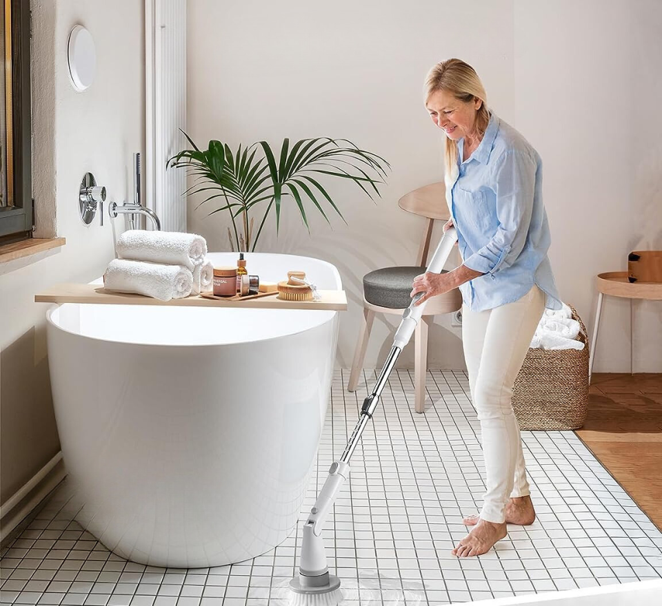 woman using the Khelfer cordless scrub brush in the bathroom