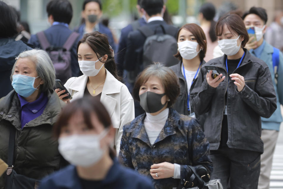 People wearing face masks to protect against the spread of the coronavirus walk on a street in Tokyo, Tuesday, April 13, 2021. (AP Photo/Koji Sasahara)