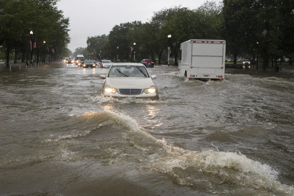 Heavy rainfall flooded the intersection of 15th Street and Constitution Ave., NW, stalling cars in the street, Monday, July 8, 2019, in Washington. (AP Photo/Alex Brandon)