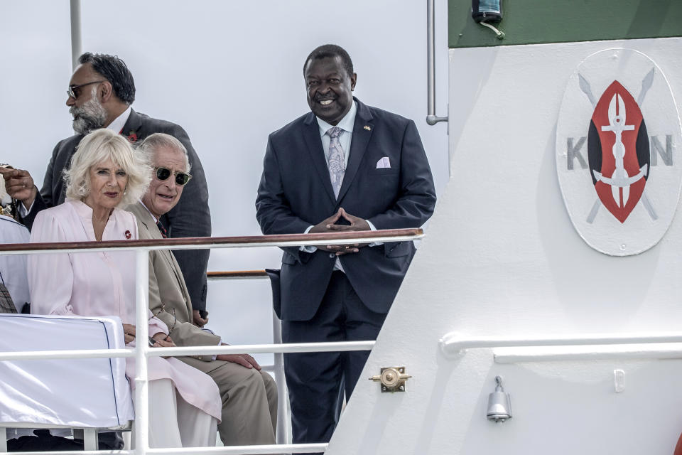 Britain's King Charles III, center, and Queen Camilla arrive aboard the Admiral's Barge to meet Royal Marines and Kenyan Marines at Mtongwe Naval Base, in Mombasa, Kenya, Thursday, Nov. 2, 2023. (Luis Tato/Pool Photo via AP)