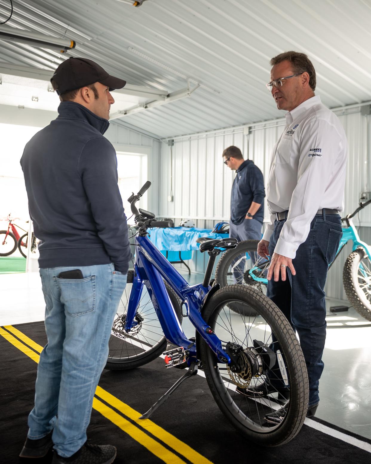 Paul Miscione (left) speaks to eBliss Global CEO Bill Klehm about bicycles at the new eBliss Experience Center in Clinton, NY on Saturday, April 27, 2024.