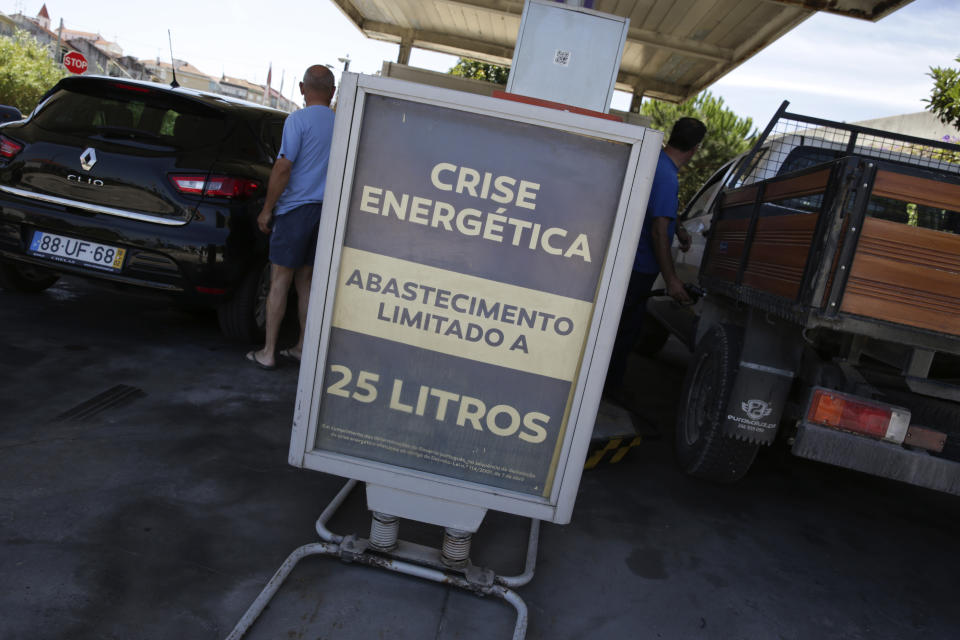 Customers refuel their vehicles at a gas station by a sign reading "Energy Crisis" and announcing a limit of 25 liters per vehicle near Aveiras, outside Lisbon, Monday, Aug. 12, 2019. Portugal is rationing gas as a precaution after some 2,000 tanker truck drivers began an open-ended strike over pay on Monday. The government has set a limit of 25 liters (6.6 gallons) for customers at gas stations until further notice. (AP Photo/Armando Franca)